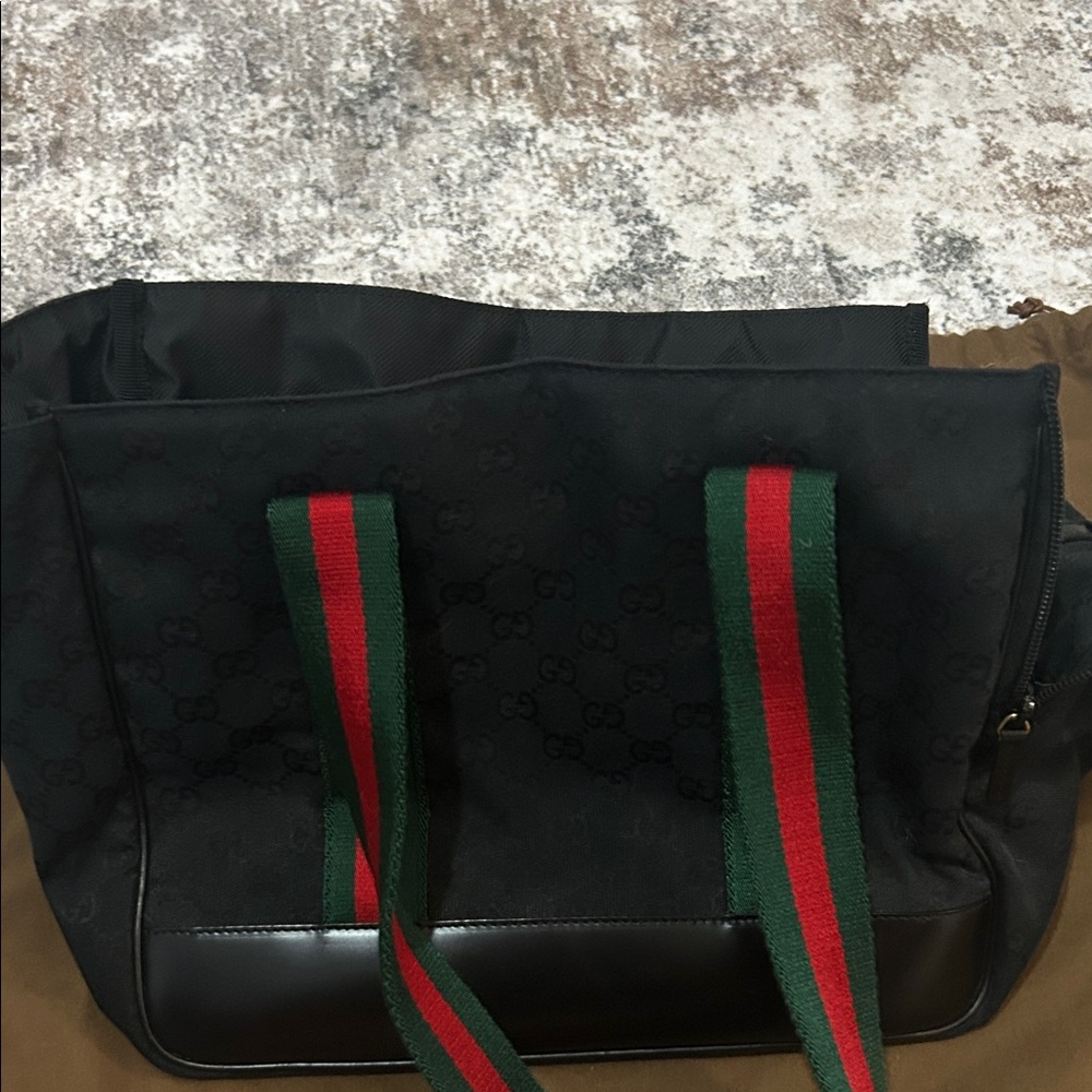 Authentic Gucci black pet carrier with signature green and red straps.